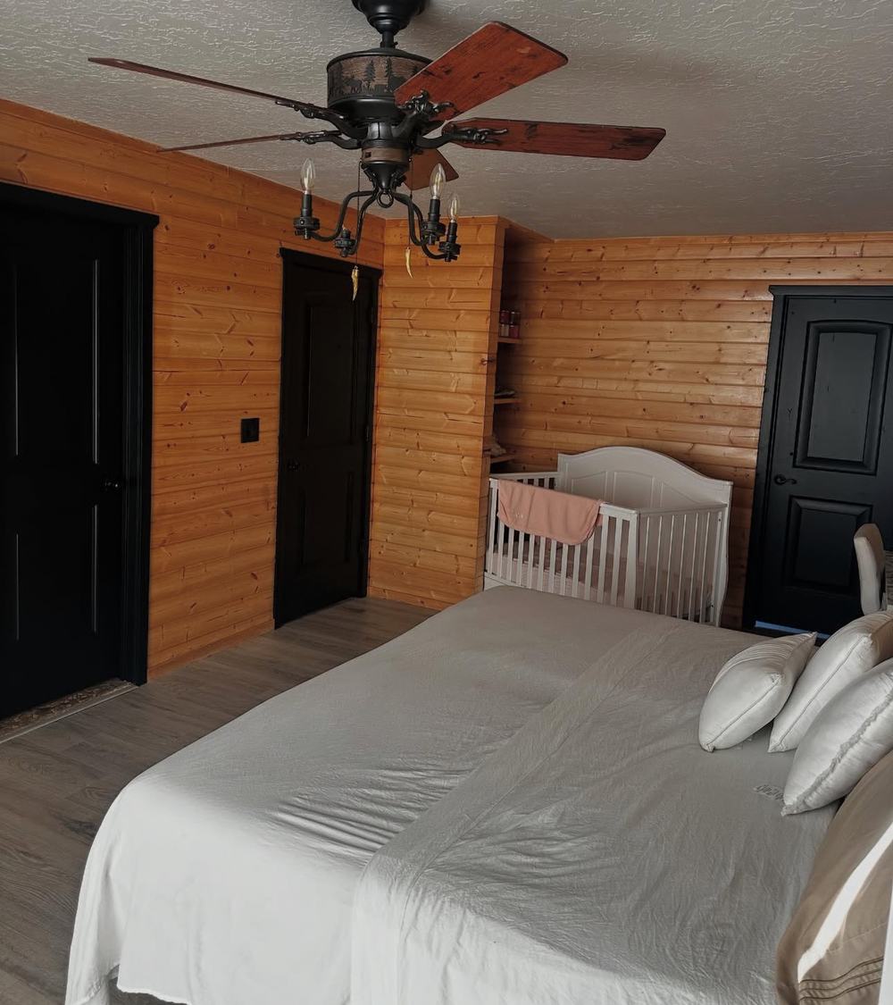 Finished log cabin style bedroom with wood paneling