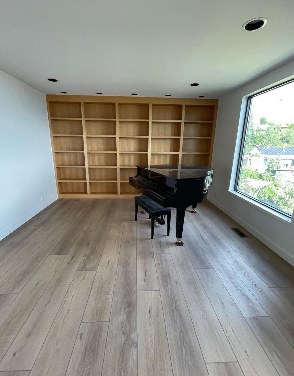 Finished piano room with built-in shelving
